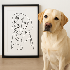 Dog sitting next to a framed line drawing of a dog on a wooden surface.